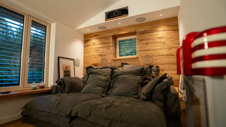 Gemütliches Heimkino mit Sofa und Holzverkleidung.