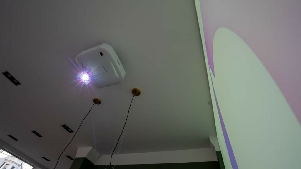 Deckenprojektor strahlt Licht auf eine Leinwand.
