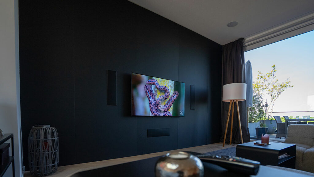 Modernes Wohnzimmer mit großem Flachbildfernseher und Terrasse.